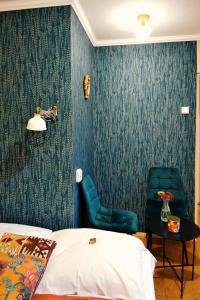 1 dormitorio con papel pintado azul y silla verde en Sunny ap in the citycentre, en Budapest