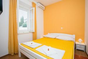 Dormitorio amarillo con cama y ventana en Yellow Room Guesthouse, en Dubrovnik