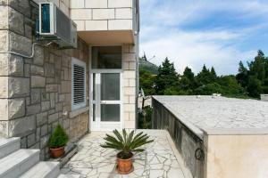 una casa con un balcón con una planta delante en Yellow Room Guesthouse, en Dubrovnik