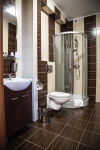 uma casa de banho com um chuveiro, um WC e um lavatório. em Hotel Stara Gorzelnia em Licheń Stary