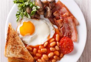 チチェスターにあるEast Pallant Bed and Breakfast, Chichesterの卵ベーコンビーンズとトーストを添えた朝食用の皿