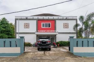 un'auto parcheggiata di fronte a un edificio di RedDoorz Syariah near Transmart Padang a Padang