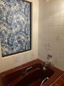 a bathroom with a sink with a blue and white wallpaper at Hotel OLDSWING Adult Only in Tokyo
