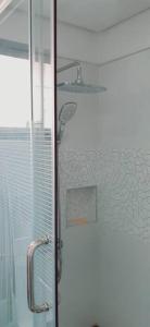 een douche met een glazen deur in de badkamer bij Avana Hills Boracay Prime Family Suite in Boracay