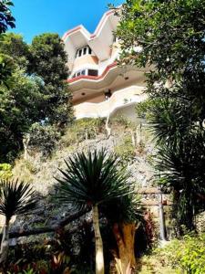 een gebouw aan de zijkant van een heuvel met bomen bij Avana Hills Boracay Prime Family Suite in Boracay