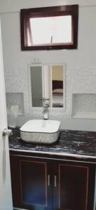 een badkamer met een wastafel en een spiegel bij Avana Hills Boracay Prime Family Suite in Boracay