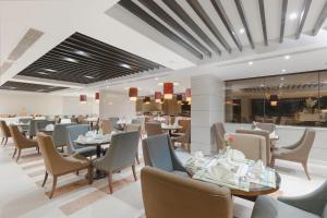 a dining room with tables and chairs and a restaurant at Royal Majestic Hotel Makkah in Mecca