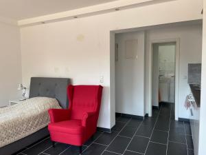 1 dormitorio con silla roja junto a la cama en MarlFlats, en Marl