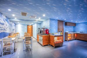 una cocina con paredes azules y mesas y sillas de madera. en 雲沐行旅 Hotel Cloud Arena-Daan en Taipéi