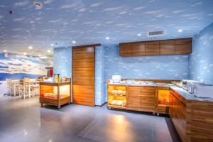 a kitchen with blue walls and wooden cabinets and a table at 雲沐行旅 Hotel Cloud Arena-Daan in Taipei