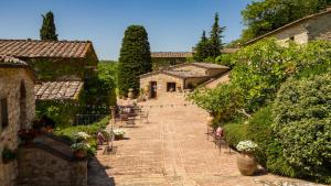 um caminho de tijolos que leva a um edifício com plantas e flores em Borgo Vescine em Radda in Chianti