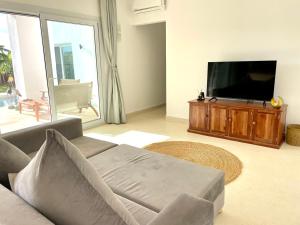 a living room with a couch and a flat screen tv at Manami Villa with Private Pool ZanzibarHouses in Kiwengwa