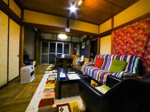 a living room with a couch and a table at Guest House Tokiwa in Fujinomiya