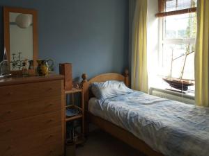 a bedroom with a bed and a dresser and a window at Nevadd - Uk12303 in Menai Bridge