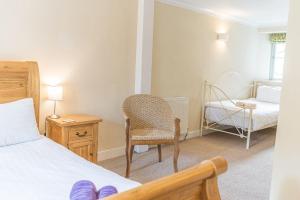 a bedroom with a bed and a chair and a crib at 2 Dixon Ground Coniston in Coniston