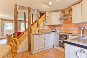 a kitchen with white cabinets and a table at 4 Dixon Ground Coniston in Coniston