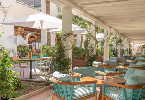 a restaurant with tables and chairs and an umbrella at INNSiDE by Meliá Alcudia in Port d'Alcudia