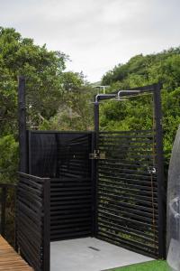 an open gate on a deck with trees in the background at Stargazing Dome - Thunzi Bush Lodge in Beachview