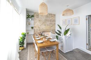 a dining room with a wooden table and chairs at Bright & beautiful 4 bedroom house with sea views in Castletown
