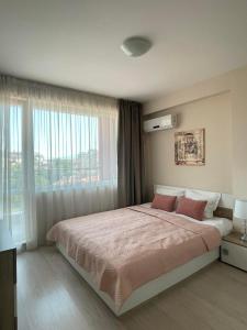 una camera da letto con un grande letto con una grande finestra di Апартамент в подножието на Стария град a Plovdiv
