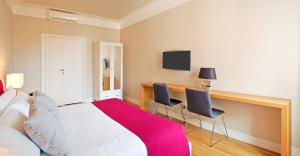 a bedroom with a bed and a desk with two chairs at Adamas Luxury Suite in Rome