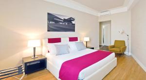 a bedroom with a large bed and a yellow chair at Adamas Luxury Suite in Rome