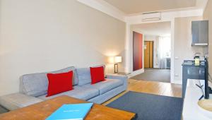 a living room with a gray couch and red pillows at Adamas Luxury Suite in Rome