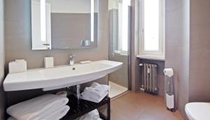 a white bathroom with a sink and a mirror at Adamas Luxury Suite in Rome +24 photos