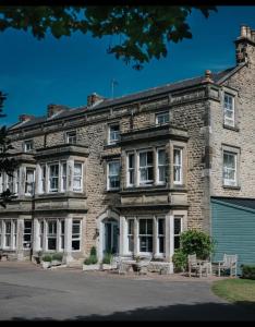 een groot bakstenen gebouw met banken ervoor bij Burythorpe House in Malton