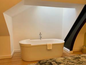 uma banheira num quarto com um lavatório em Quebecs Luxury Apartments em Leeds