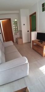 sala de estar con sofá blanco y escritorio en Marianna casa vacanza, en Azzate