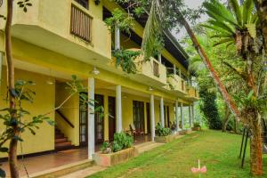 an exterior view of a building with a yard at Blue Magpie Lodge Sinharaja in Kudawe