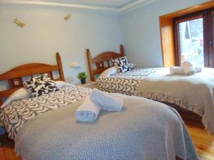 a bedroom with two beds with towels on them at casa Panticosa Sunset WOWRURAL in Panticosa