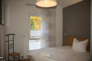 una camera con un letto bianco e una finestra di Ferienwohnungen Buchenweg a Ostseebad Sellin