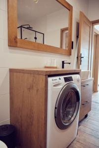 uma máquina de lavar roupa na casa de banho com um espelho em WieliczkaHome 1st floor + garden + parking em Wieliczka