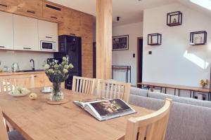 kuchnia i jadalnia z drewnianym stołem w obiekcie WieliczkaHome 1st floor + garden + parking w Wieliczce