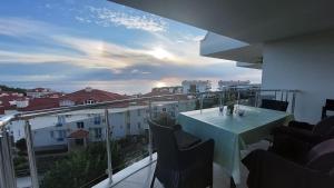 balcón con mesa y sillas en Sunset Beach Vip 1 Residences, en Konaklı