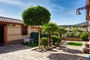 d'une terrasse avec une table et des arbres dans une cour. dans l'établissement Los Monteros Sierra de Francia, à Aldeanueva de la Sierra