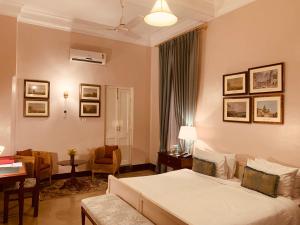 - une chambre avec un lit et un salon dans l'établissement The Elgin Fairlawn, Kolkata, à Kolkata