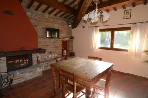 a dining room with a wooden table and a fireplace at Agriturismo Maloura in Savignano sul Rubicone