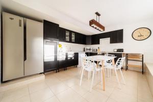 a kitchen with a table and chairs and a clock at Moser Living Premium Apartments in Mogán