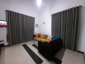 sala de estar con sofá y TV en Sobaya Residence, en Ambalantota