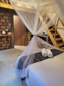 a bedroom with a bed with a mosquito net at Moz T's Lodge in Inhambane