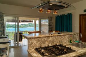 a kitchen with a stove top oven next to a counter at TOP VIEW RETREAT SELFCATERING in Anse a La Mouche