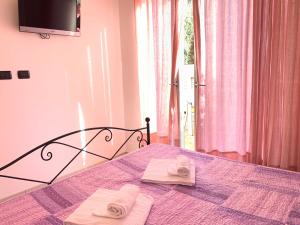 1 dormitorio con 1 cama con 2 toallas en Appartamento Fiordaliso Residenza Prealba, en Levanto