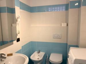 La salle de bains bleue et blanche est pourvue de toilettes et d'un lavabo. dans l'établissement Appartamento Fiordaliso Residenza Prealba, à Levanto