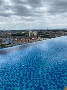 a large swimming pool with a city in the background at Damen Suite Sunway Subang by DW in Subang Jaya