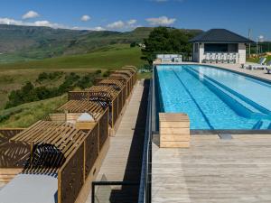 Cayley Mountain Resort في Champagne Valley: مسبح كبير مع كراسي بجانب مبنى