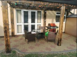 a patio with a table and chairs and a grill at Spacious 2BDR Apartment, WIFI+ Great TV in Romford
