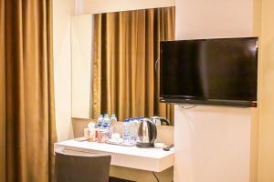 a hotel room with a table with a television on it at OS Hotel Airport Batam in Batam Center